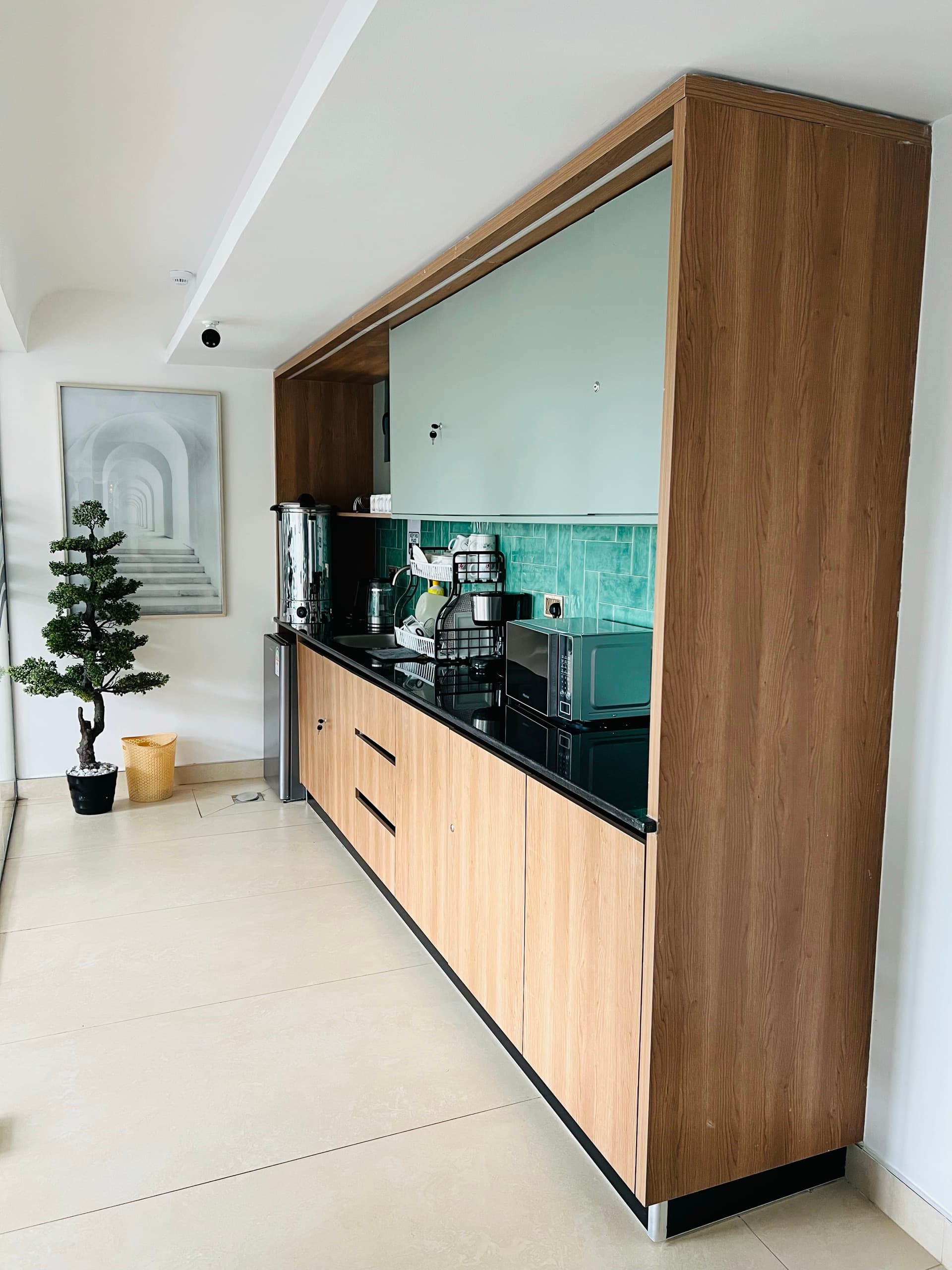 Executive pantry with oak cabinetry, black granite worktop and teal glazed backsplash
